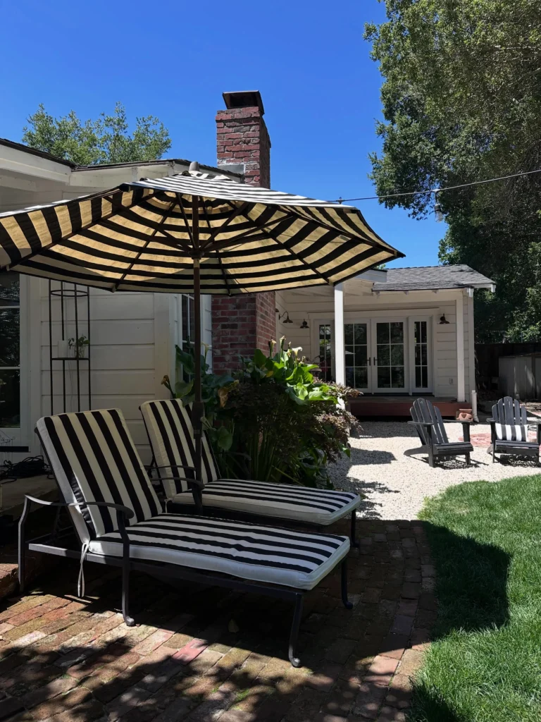 Black and White Striped Backyard with Chaise Loungers, Gravel Patio, and Adirondack Chairs