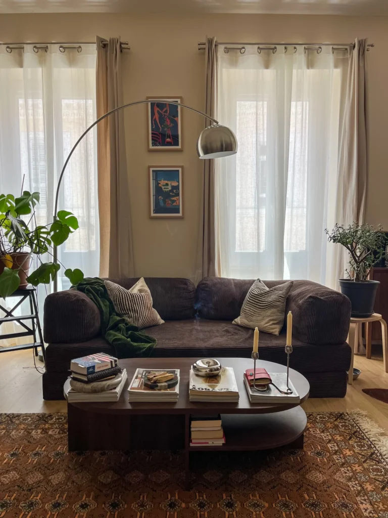 Chocolate Corduroy Sofa With Arc Lamp and Stacked Coffee Table Books